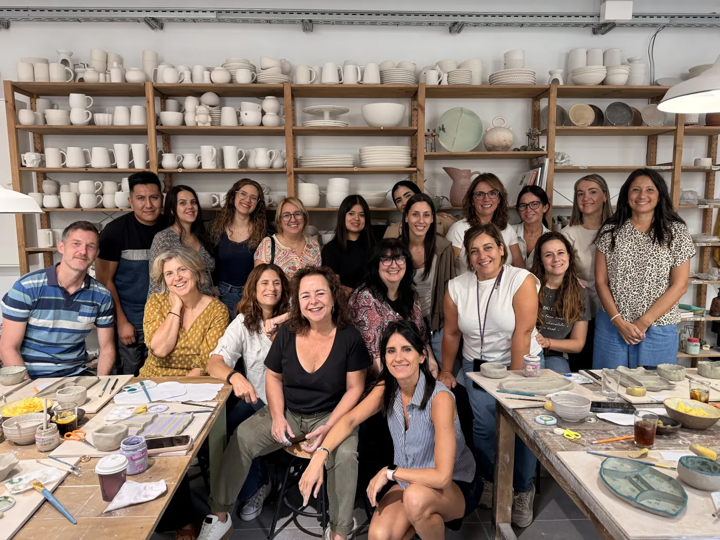 Equipo de empresa entre piezas y herramientas de cerámica